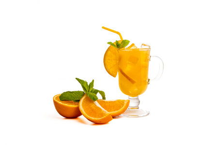 Orange cocktail in a glass with ice, a refreshing summer drink. Cold and orange punch with a slice of orange and mint on a white background. Copy space. High quality photoの写真素材