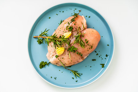 Raw chicken breast marinated with rosemary, garlic and herbs on a white background. High quality photoの写真素材