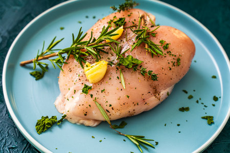 Marinated chicken breast with garlic and rosemary on a blue plate. Close-up. Healthy eating concept. High quality photoの写真素材