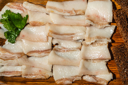 Pork lard cut into slices with rye bread on a wooden board. High quality photoの写真素材
