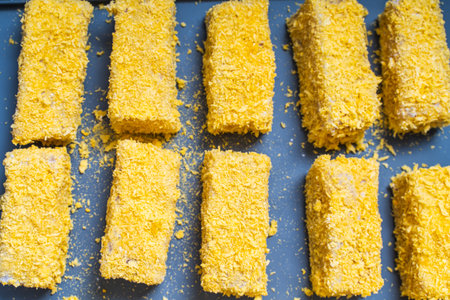 Fish sticks or tempura rolls on a gray baking mat. Flat layout, Top view. High quality photo