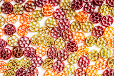 Background with texture dry Italian pasta Rotelle. Different flavors and colors: egg, spinach, carrot, pepper. High quality photoの写真素材
