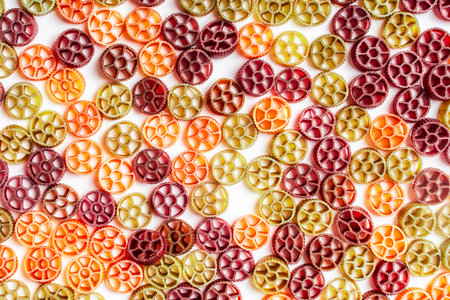 Background with texture dry Italian pasta Rotelle. Different flavors and colors: egg, spinach, carrot, pepper. High quality photoの写真素材