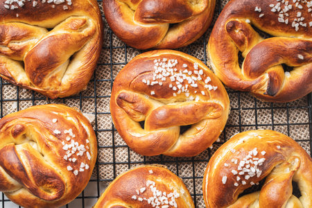 Traditional pretzels with coarse salt on black lattice on canvas fabric, Food background pattern. Top view, close-up. Flat layout. High quality photoの写真素材