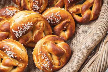 Pretzels with coarse salt. on canvas in a wicker basket with ears of wheat. High quality photoの写真素材
