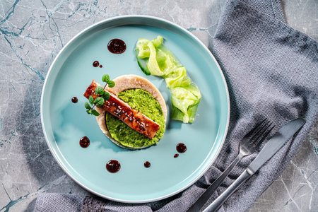 Cod fillet with spinach and broccoli puree and cauliflower on a blue plate. The concept of healthy and dietary nutrition. Top view. High quality photoの写真素材