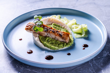 Cod fillet with spinach and broccoli puree and cauliflower on a blue plate. The concept of healthy and dietary nutrition.の写真素材