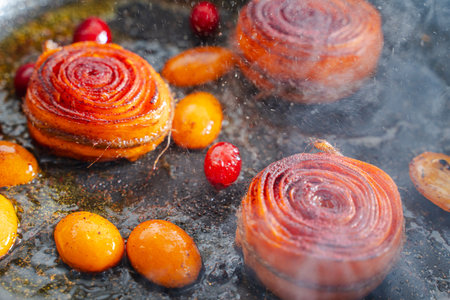 Close-up The process of making a carrot dessert, carrots, kumquat and cranberries are fried in a pan. Close-up. Healthy Nutrition Concept. High quality photoの写真素材