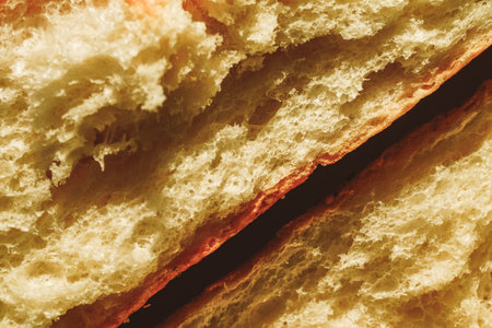 Close-up of a French baguette with sesame seeds. Background with bread texture. Dried wheat loaf,...
