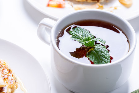 A cup of tea with a sprig of mint, close-up. A white cup with a thirst-quenching drink. High quality photoの写真素材