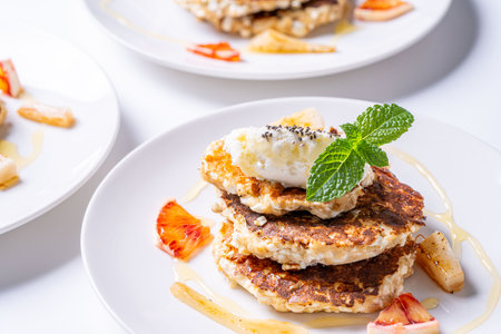 Healthy, dietary breakfast. Cottage cheese pancakes with cream cheese, orange, honey and mint on a...