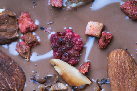 Handmade chocolate close-up. Assorted chocolate with almonds, freeze-dried raspberries and strawberries. . Background for using banners and menus. High quality photoの写真素材