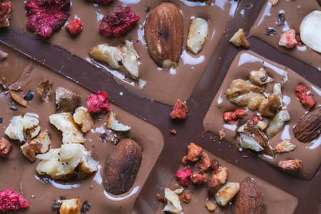 Handmade chocolate close-up. Assorted chocolate with almonds, freeze-dried raspberries and strawberries. . Background for using banners and menus. High quality photoの写真素材
