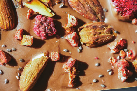 Handmade chocolate close-up. Assorted chocolate with almonds, freeze-dried raspberries and strawberries. . Background for using banners and menus. High quality photoの写真素材
