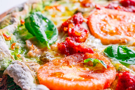 Pizza on green spinach dough with tomatoes and basil. The concept of healthy eating. Close-up. Pizza textured background. High quality photoの写真素材