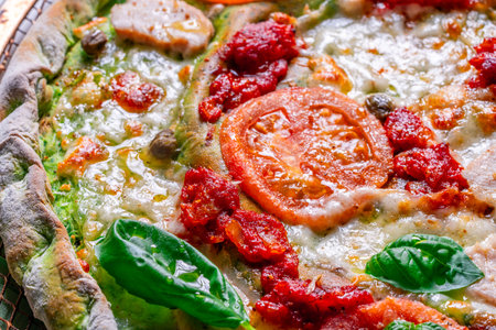 Pizza on green spinach dough with tomatoes and basil. The concept of healthy eating. Close-up. Pizza textured background. High quality photoの写真素材