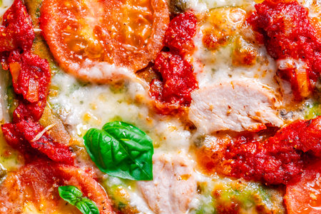 Pizza on green spinach dough with tomatoes and basil. The concept of healthy eating. Close-up. Pizza textured background. High quality photoの写真素材