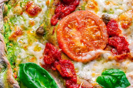Pizza on green spinach dough with tomatoes and basil. The concept of healthy eating. Close-up. Pizza textured background. High quality photoの写真素材