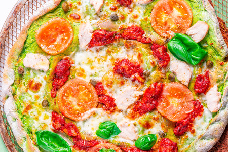 Pizza on green spinach dough with tomatoes and basil. The concept of healthy eating. Close-up. Pizza textured background. High quality photoの写真素材