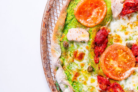 Pizza on green spinach dough with cheese, tomatoes, basil and olive oil. Space for text. View from above. High quality photoの写真素材