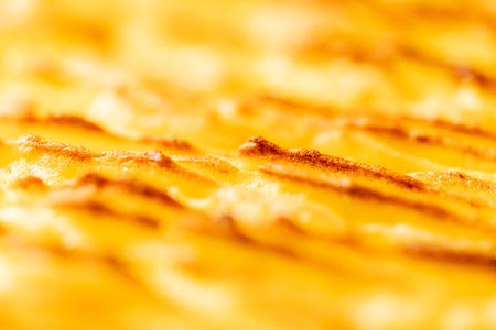 Background with the texture of baked, browned mashed potatoes close-up. Selected focus. Blurred background. High quality photoの写真素材