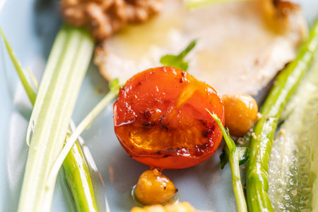 Toasted cherry tomato close-up with green asparagus and corn. High quality photoの写真素材