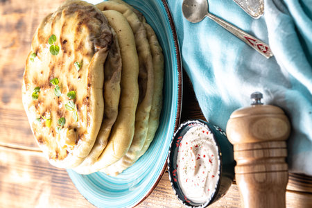 Traditional Caucasian, Eastern dish. Flatbread stuffed with minced meat with sauce on a turquoise...