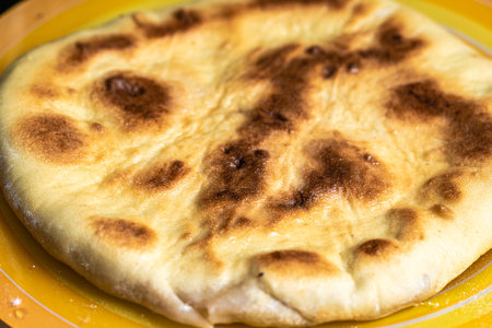 Flatbread stuffed with minced meat on a yellow plate. High quality photoの写真素材