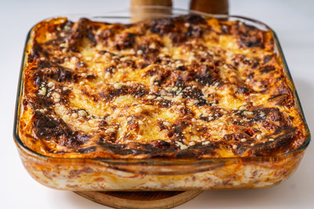 Lasagna in a glass baking dish according to a traditional Italian recipe on a white table. High quality photoの写真素材