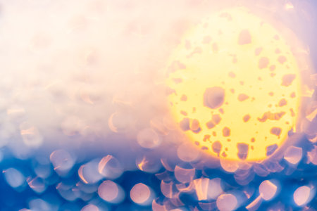 Raindrops on the window against the background of the setting sun. Background with glass and drip texture. High quality photoの写真素材