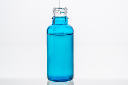Collagen and hyaluronic serum for the face and around the eyes. A blue bottle on a white background. Copyspace. High quality photoの写真素材
