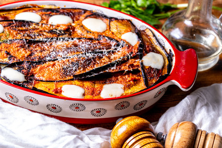 Eggplant baked with tomatoes and cheese in a baking dish on the table with a white napkin. Italian cuisine. High quality photoの写真素材