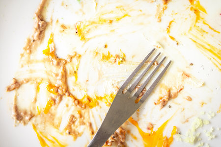 Fork on a dirty white plate with leftovers. High quality photoの写真素材