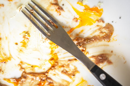 Fork on a dirty white plate with leftovers. High quality photoの写真素材
