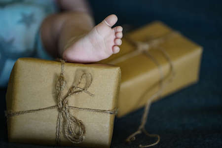 Newborn baby feet on the background of a gift box. Selective focus. Holiday.の写真素材