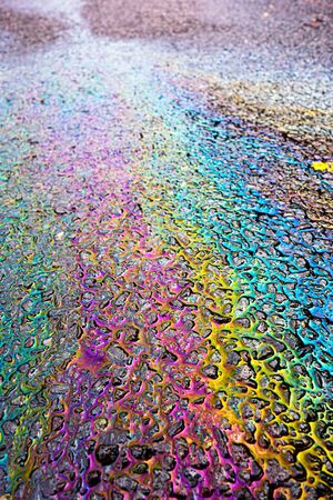 Petrol Oil on a Road Running Down a Gutter Drainの写真素材