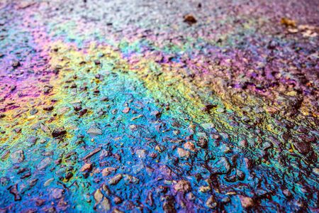 Petrol Oil on a Road Running Down a Gutter Drain
