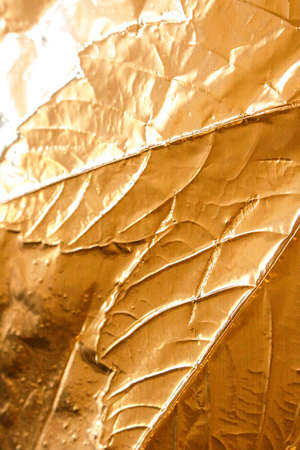 A gold Holographic Foil Leaf and Leaves with Veins Texture Shiny Patternの写真素材