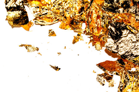 Vibrant Gold Leaf Pieces Close Up on A White Background as Decorative Piecesの写真素材