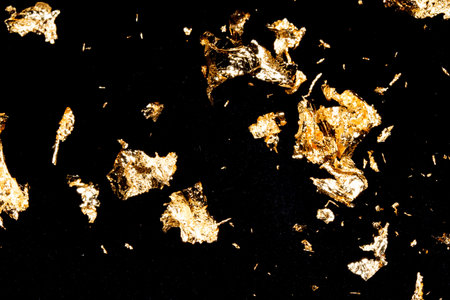 Vibrant Gold Leaf Pieces Close Up on A Background as Decorative Piecesの写真素材