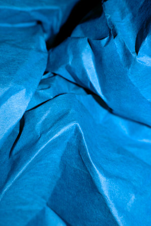 blue creased crumpled paper background grunge texture backdrop.の写真素材