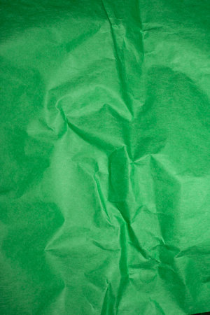 Green creased crumpled paper background grunge texture backdrop.