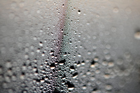 Close Up of Condensation Floating Liquid Water Bubbles and Drips on Glass from Rain