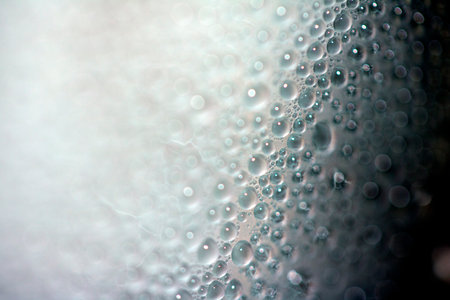 Close Up of Condensation Floating Liquid Water Bubbles and Drips on Glass from Rainの写真素材