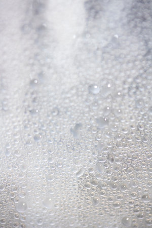 Close Up of Condensation Floating Liquid Water Bubbles and Drips on Glass from Rainの写真素材