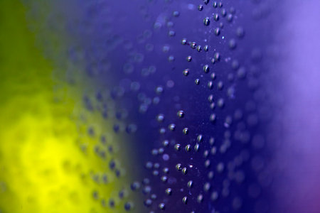 Close Up of Condensation Floating Liquid Water Bubbles and Drips on Glass from Rainの写真素材