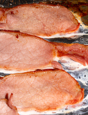 Close Up of Fried Grilled Bacon Slices On Tin Foilの写真素材