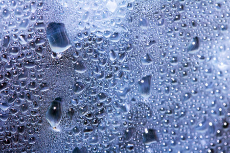 Close Up of Condensation  Water Liquid Bubbles and Drips on Glass from Rain Abstract Background
