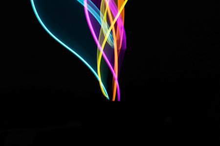Neon Rainbow Light on Black Background Abstract Lines Swirls and Waves