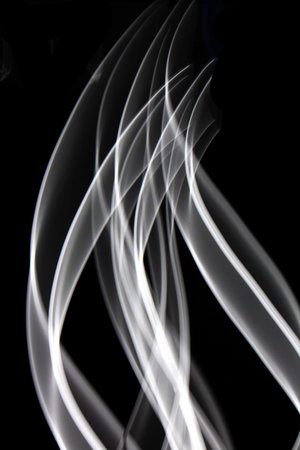 Neon Black and White Light on Black Background Abstract Lines Swirls and Wavesの写真素材